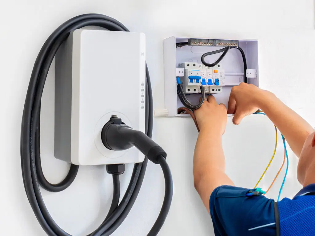 PowerHUB Homes technician installing EV charger in a garage for a homeowner